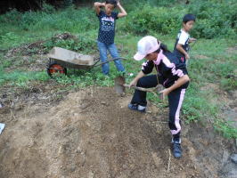 小川に流れ出た土を取り除く子供達