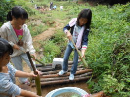 竹の水鉄砲で遊ぶ子供達